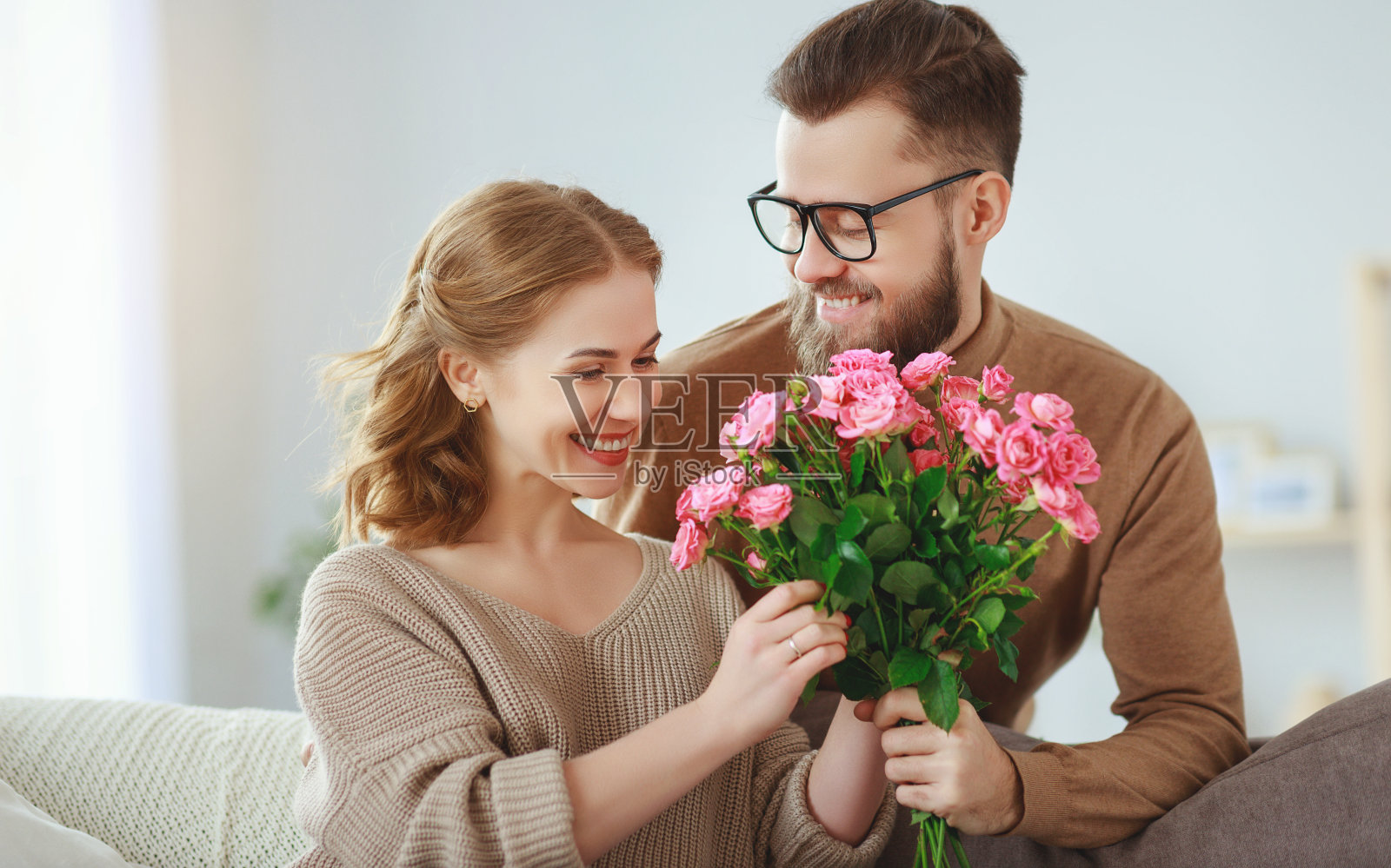 快乐的相爱。丈夫在家给妻子送花照片摄影图片