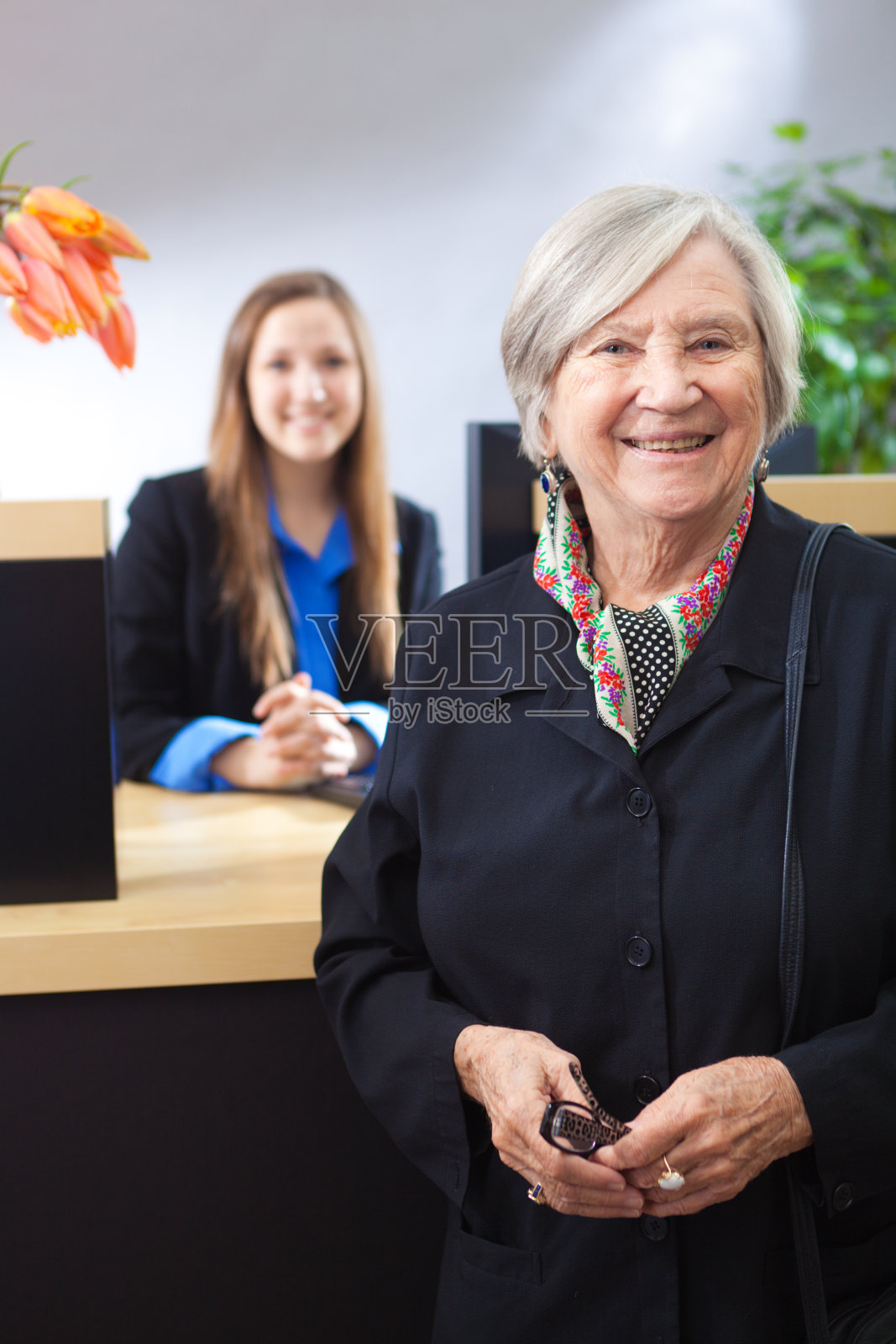 一个快乐的顾客在零售银行柜台与银行出纳员的肖像照片摄影图片