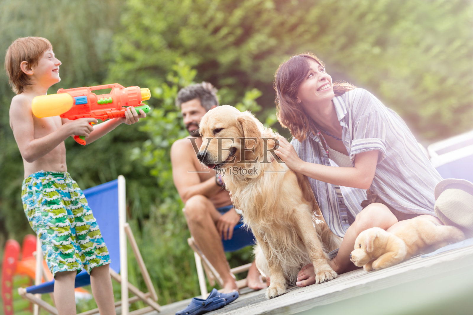 倾斜拍摄的家庭与金毛猎犬在码头上照片摄影图片