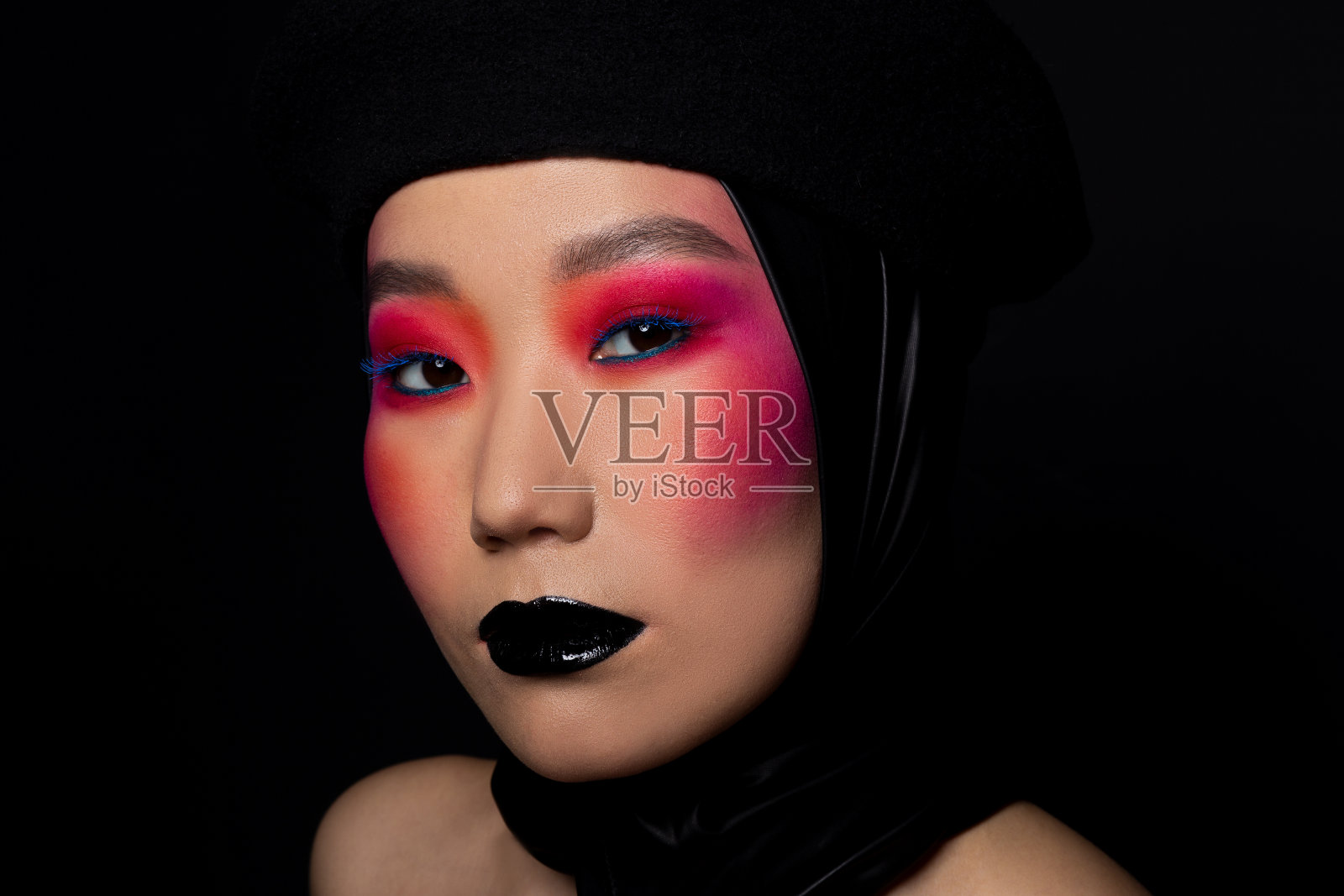 年轻的亚洲女人戴着黑色贝雷帽，涂着黑色唇膏照片摄影图片