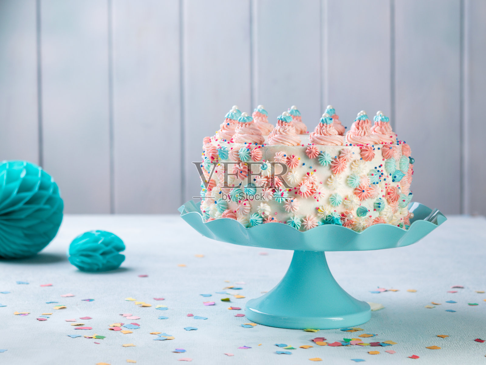 香草奶油生日蛋糕与彩色点缀在一个中性的背景。照片摄影图片