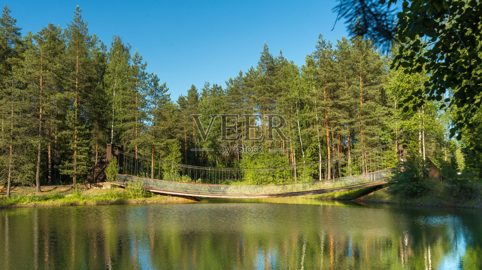 森林中的蓝色湖泊，俄罗斯的山水，美丽的自然。美丽的桥。照片摄影图片