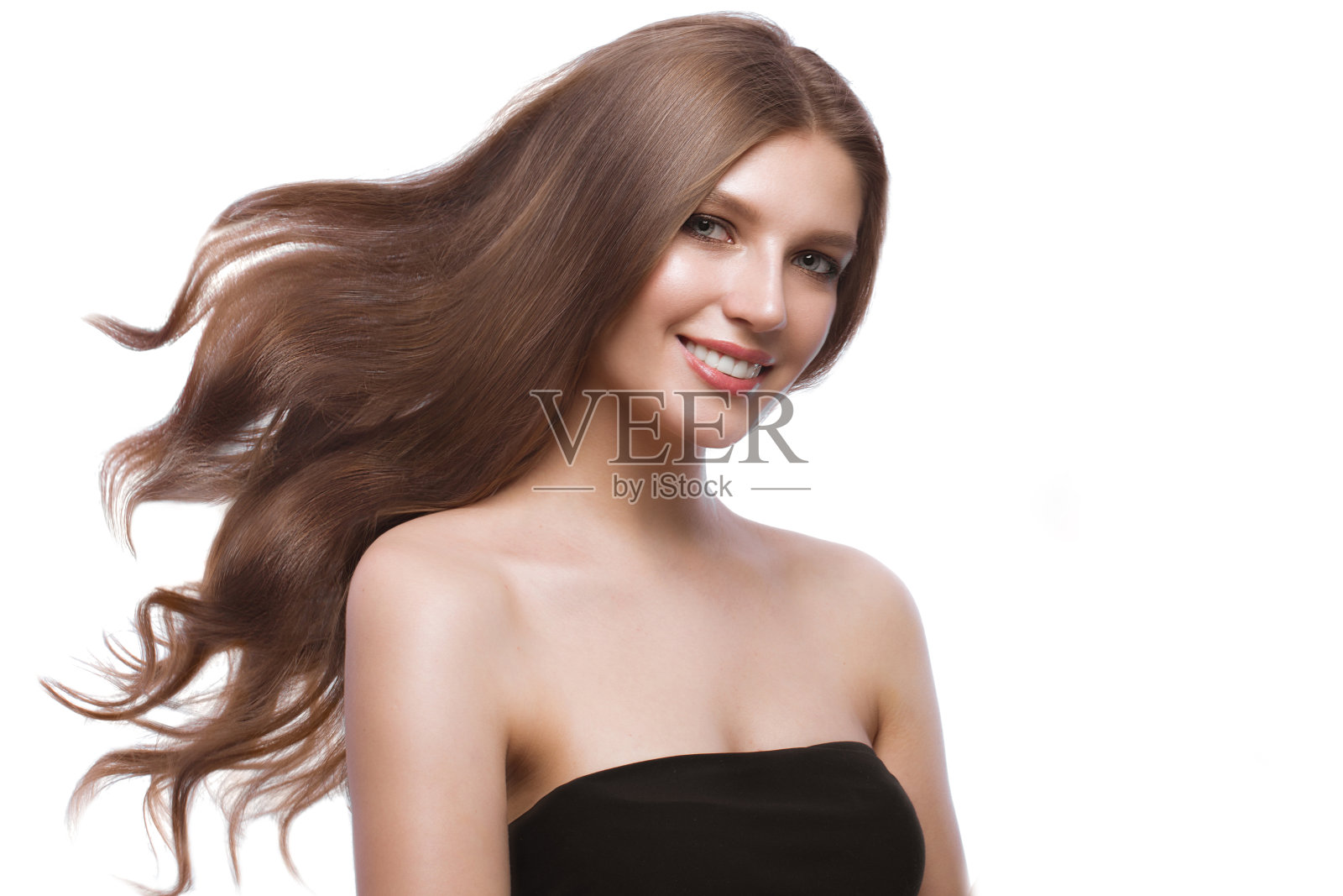 美丽的棕色头发的女孩在移动，一个完美光滑的头发，和经典的化妆。照片摄影图片