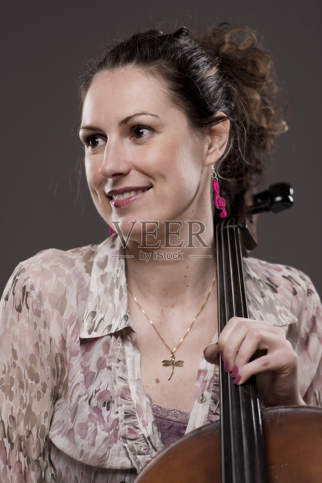 美丽的黑发女性大提琴家与她的乐器照片摄影图片