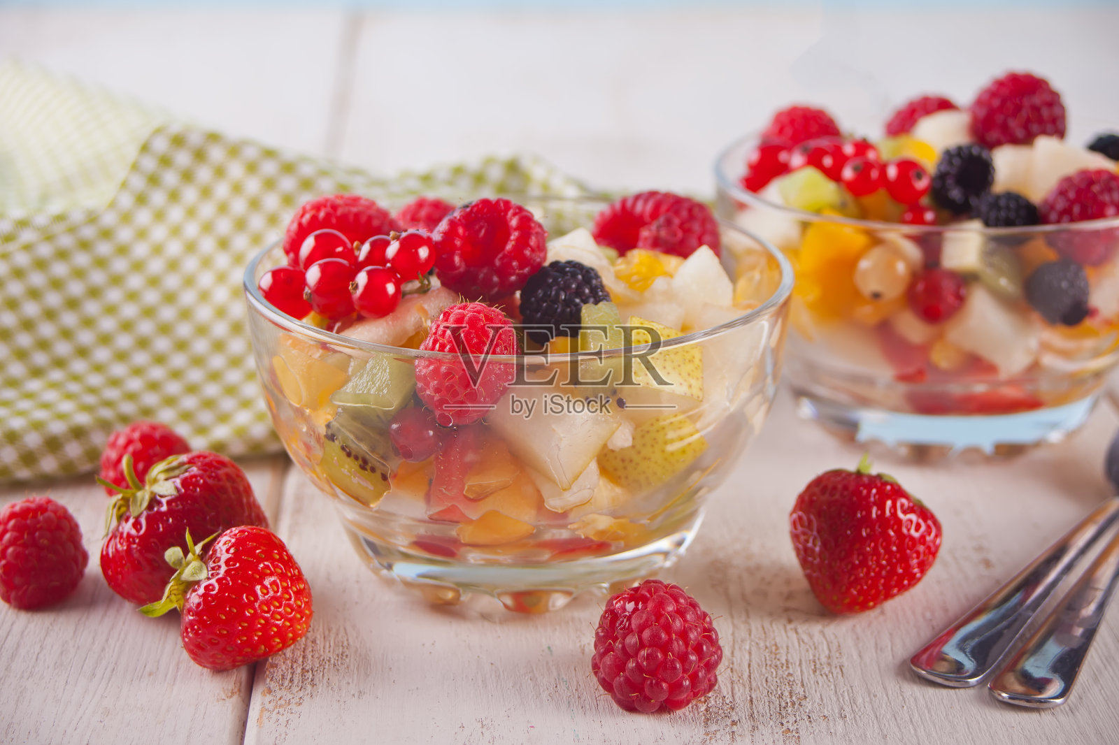 在混凝土背景上用碗盛着新鲜水果和浆果的沙拉照片摄影图片