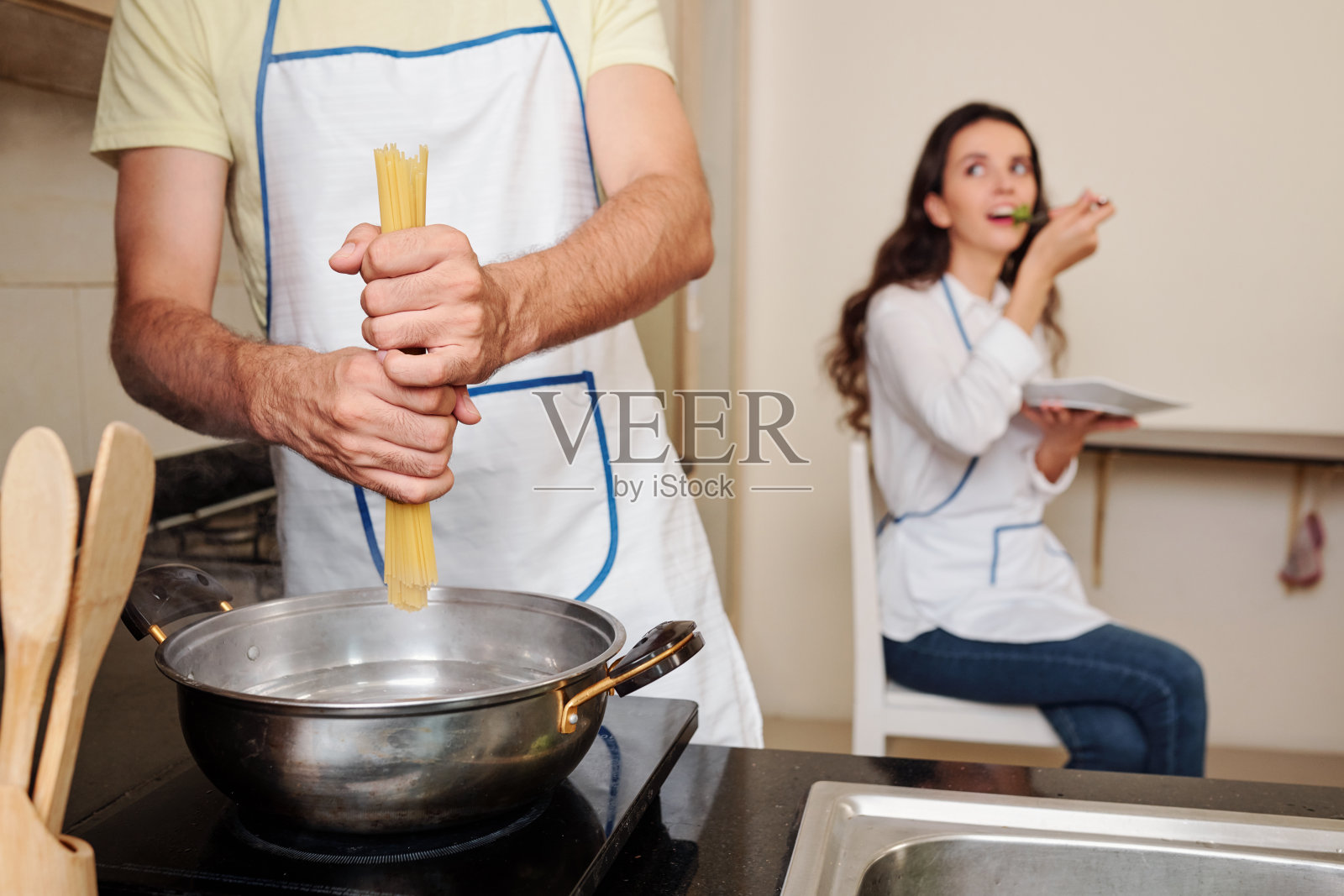 当丈夫煮意大利面时照片摄影图片