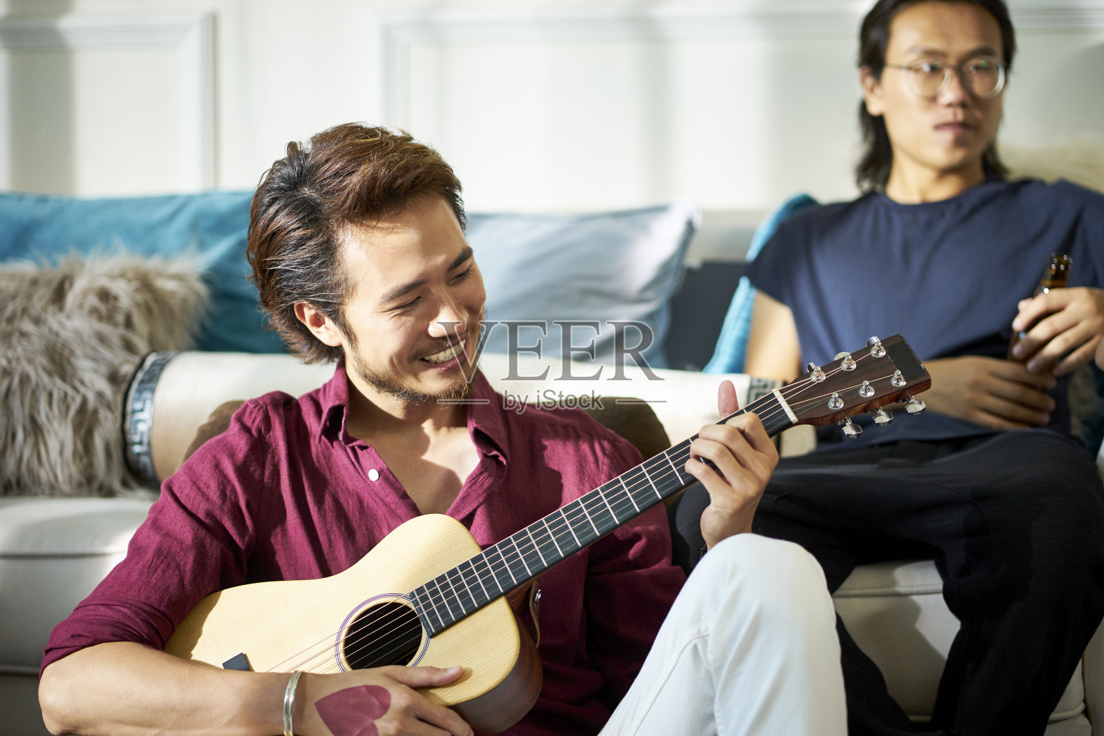 年轻的亚洲音乐家唱吉他照片摄影图片