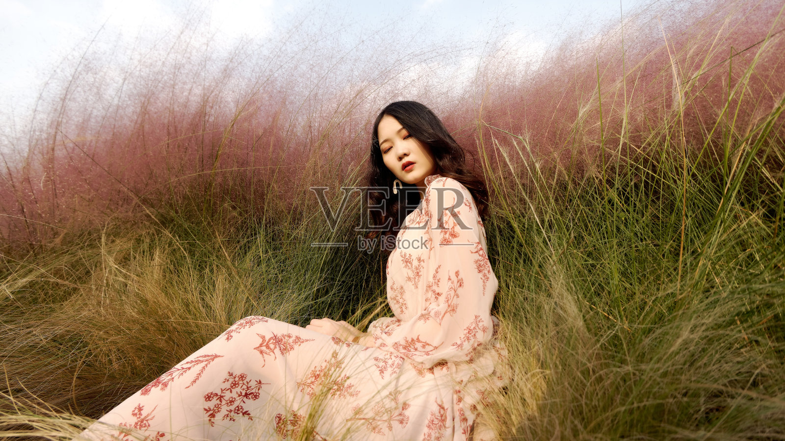一个美丽的中国年轻女子的肖像穿着粉红色的衣服坐在粉红色的头发，完全沉浸在她自己的感情，复古模式，宽镜头。照片摄影图片