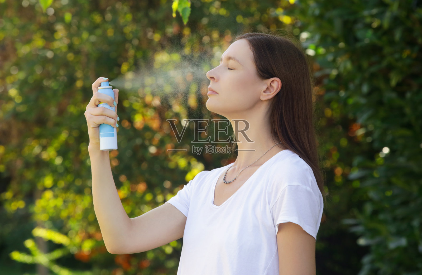 女人在脸上喷洒喷雾，夏日护肤理念照片摄影图片
