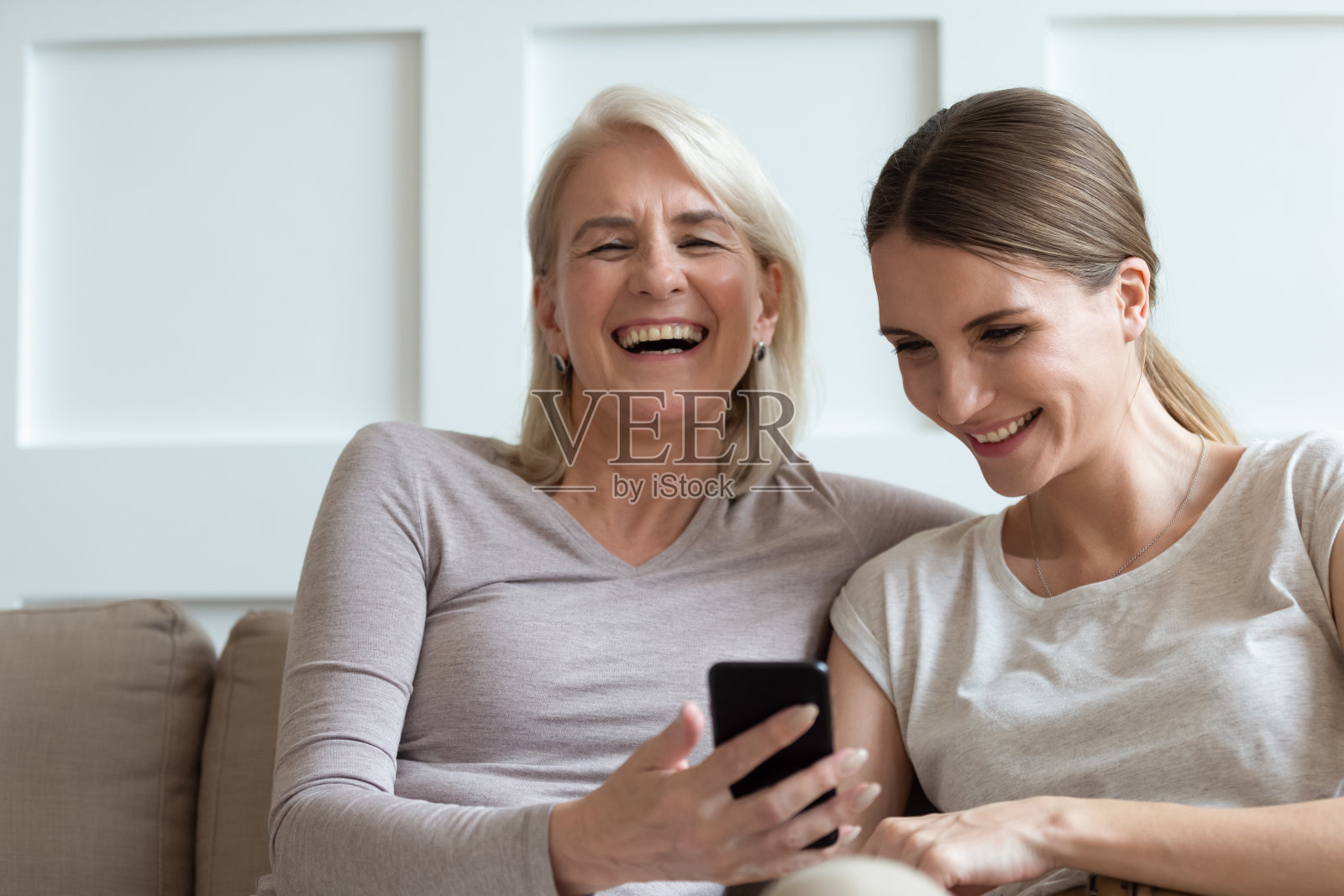 妈妈和成年女儿在智能手机上看搞笑视频笑照片摄影图片