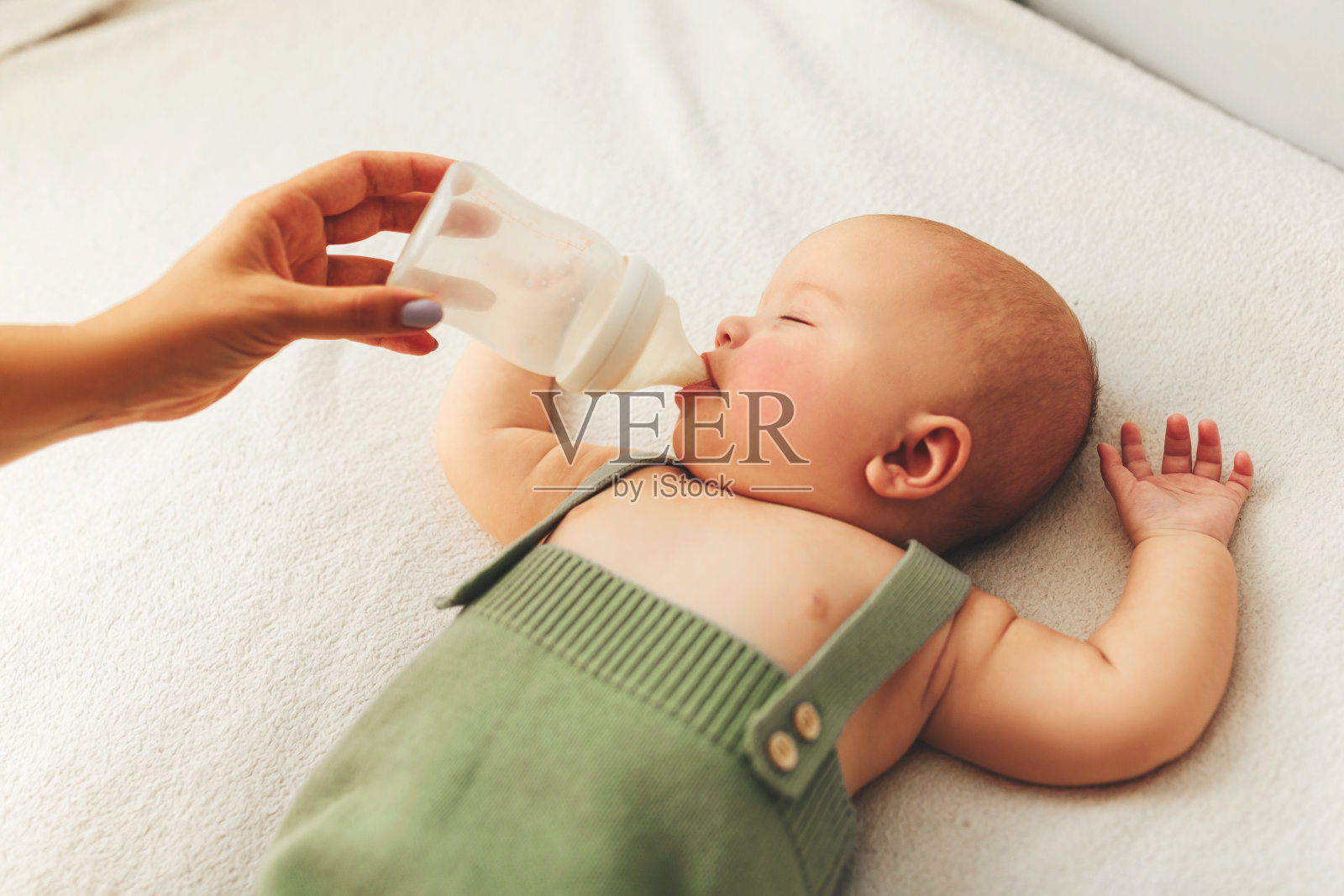 护理宝宝。用奶瓶喂新生儿。母乳喂养的问题。母亲的爱和温暖。照片摄影图片