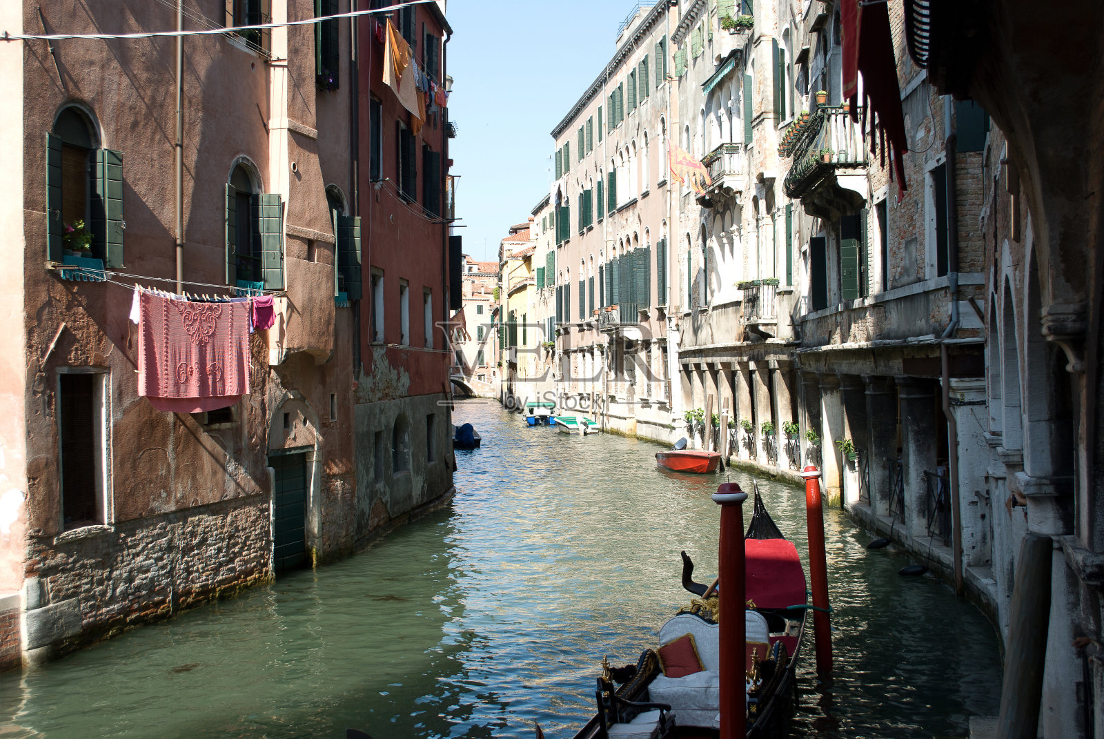 在威尼斯的运河里用停泊的平底船晾着衣服照片摄影图片