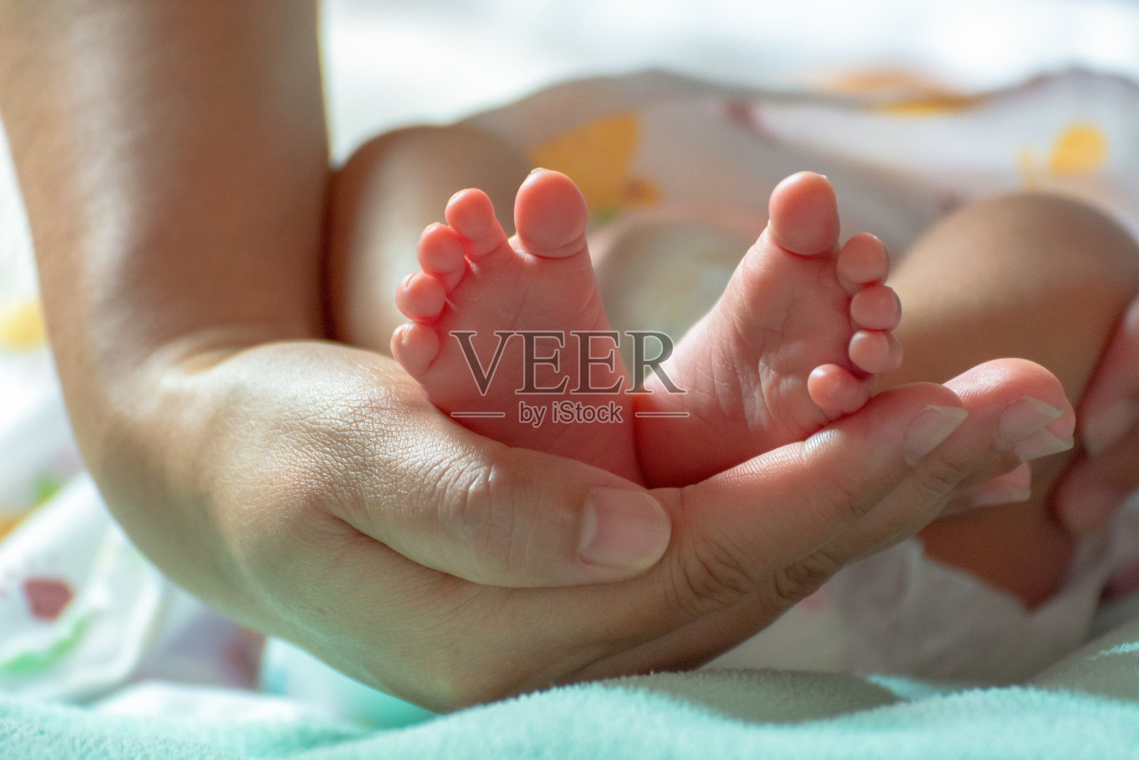婴儿的脚在妈妈的手里。妈妈和孩子。幸福的家庭的概念。美丽的母性概念形象照片摄影图片