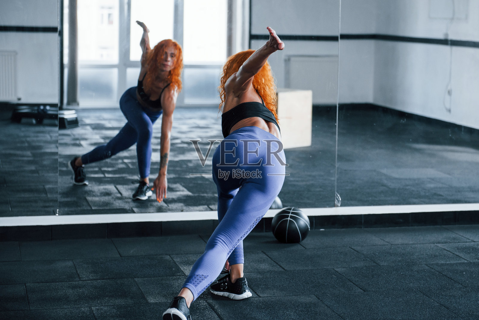 照片。喜欢运动的红发女孩白天去健身房健身。肌肉发达的身体类型照片摄影图片