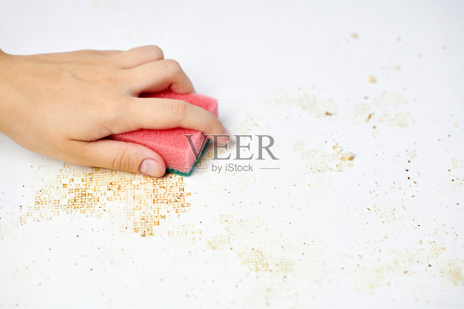 清洁厨房的桌子上。女人手里拿着粉色海绵，用来清除灰尘、面包屑和剩饭剩菜。家务照片摄影图片