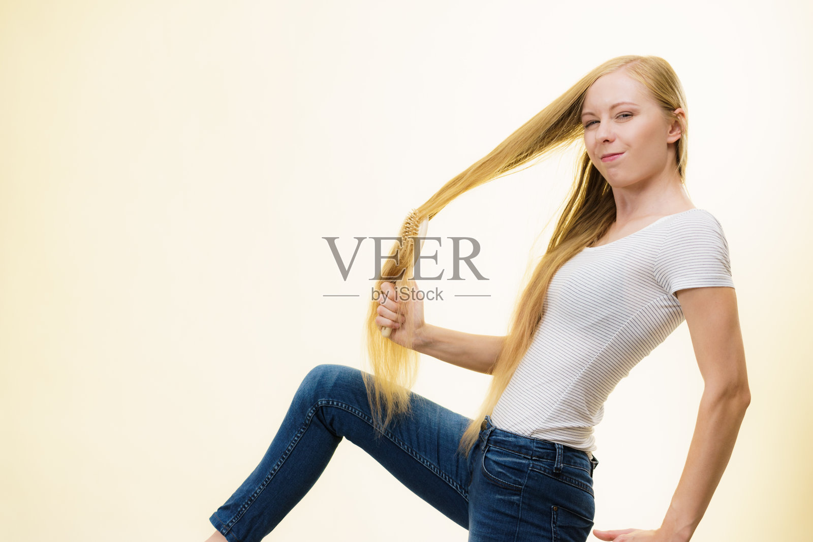 金发女孩正在梳理她的长发照片摄影图片
