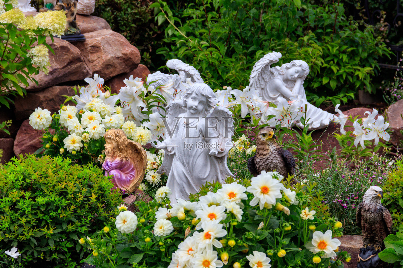 花坛上的天使和小鸟雕像照片摄影图片