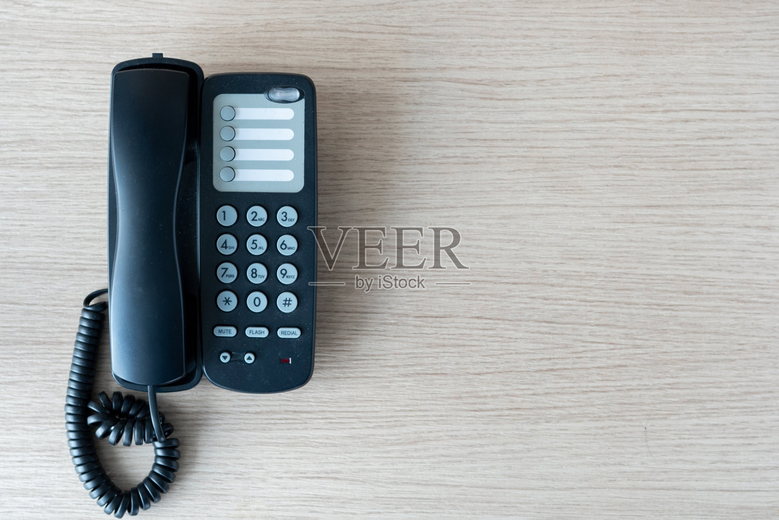 旧的黑色电话在商业办公桌上的木头上被用来联系连接，上面在桌面上查看员工正在等待来自客户和其他部门的消息。照片摄影图片
