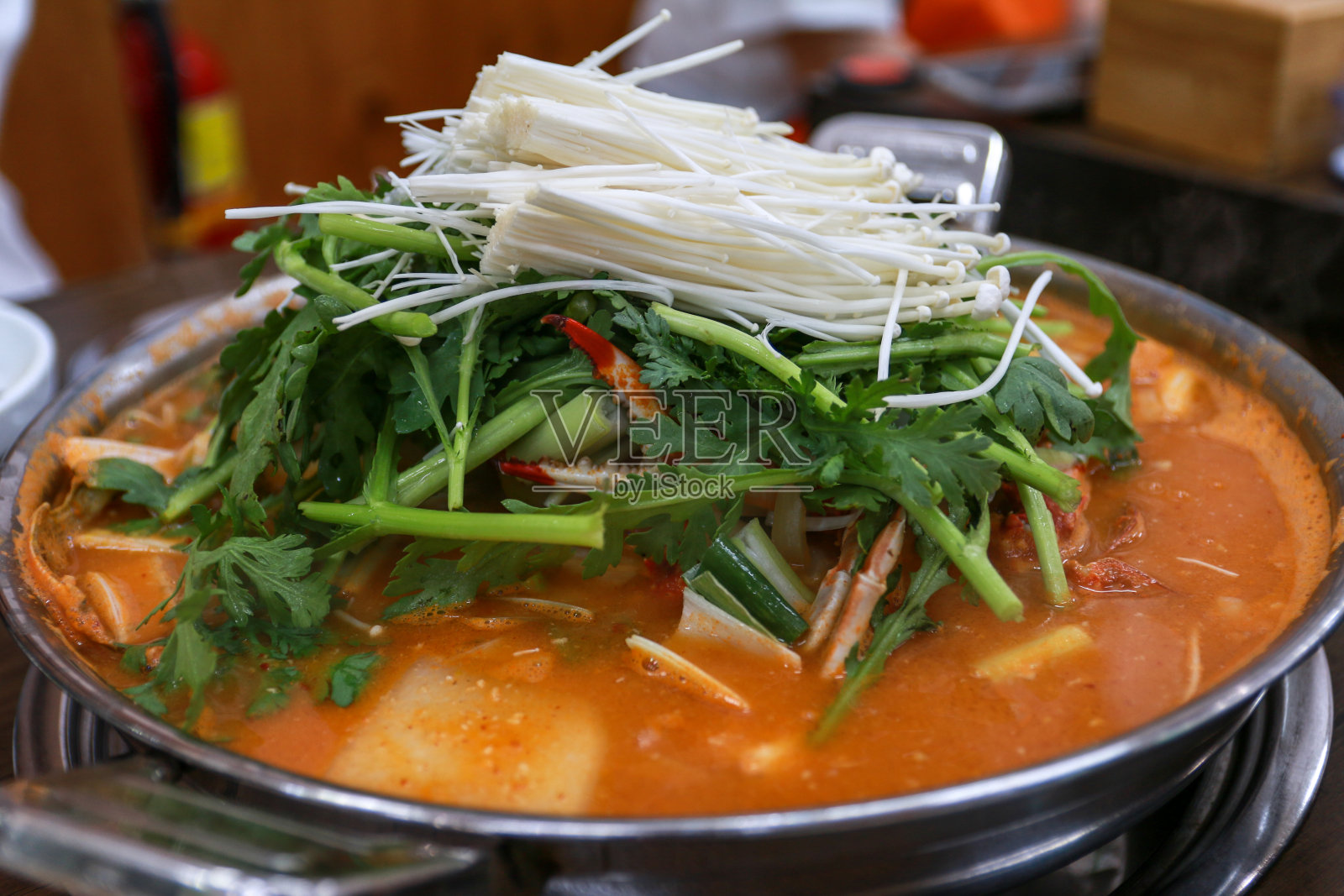 韩国传统食物辣蟹炖汤，配上金针菇和蔬菜照片摄影图片
