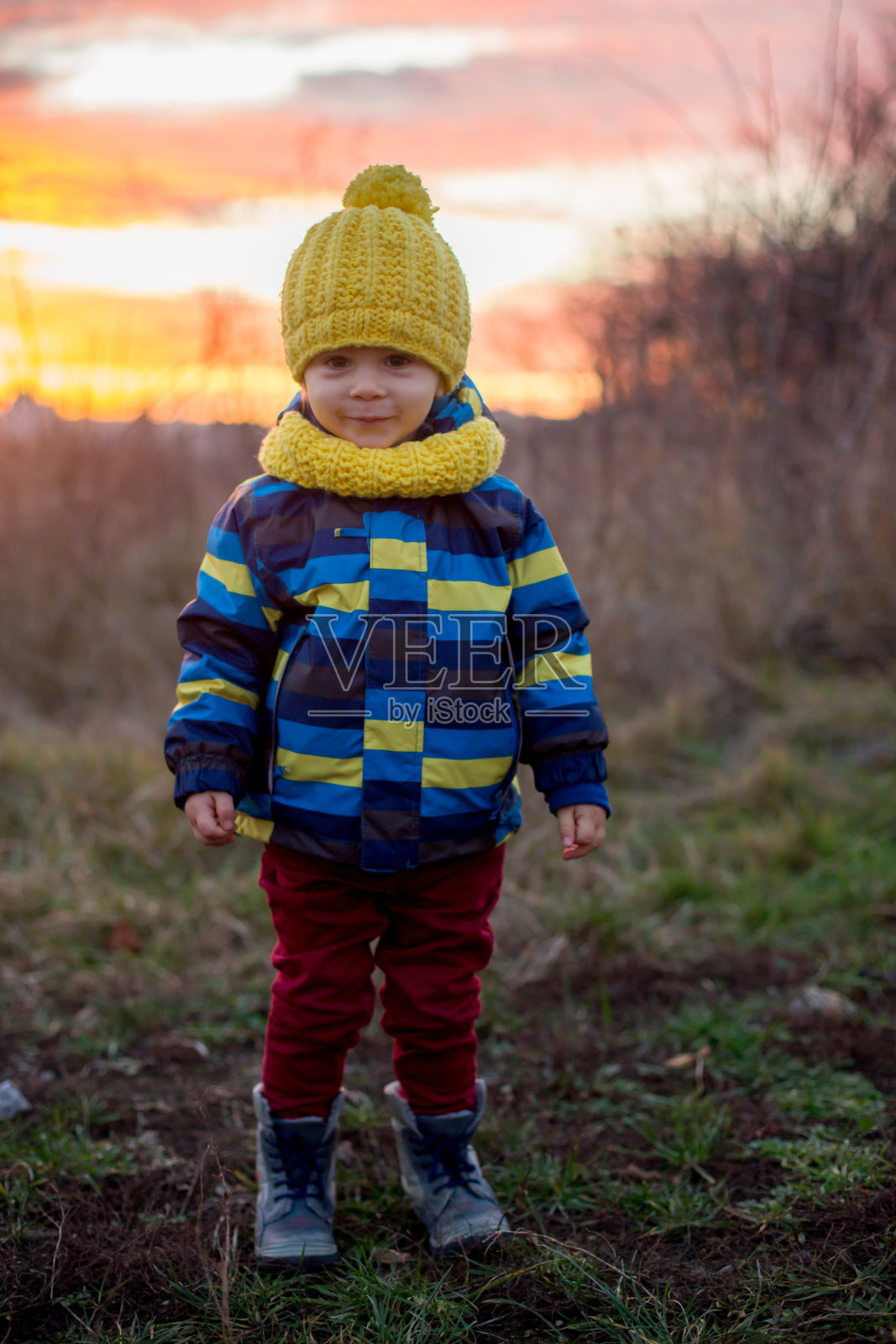 接近秋冬的甜蜜微笑的蹒跚学步的男孩肖像照片摄影图片