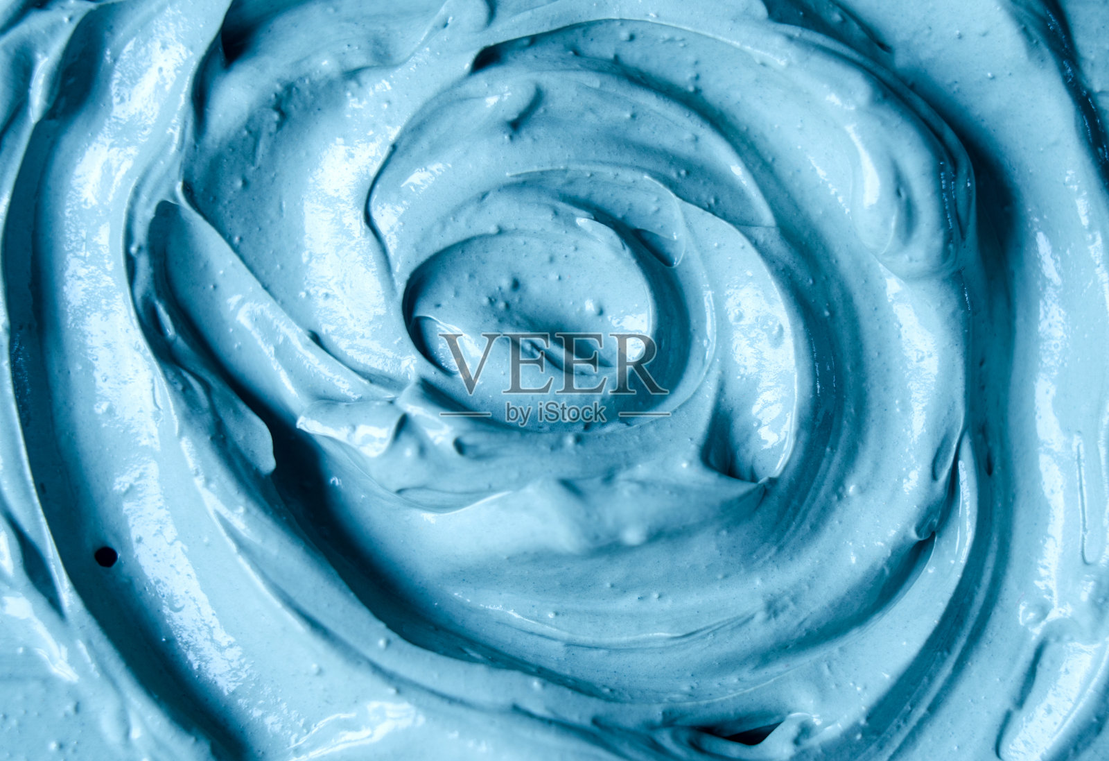 淡蓝色面膜(面霜、裹身)纹理近距离呈现。抽象背景与圆形笔触。照片摄影图片
