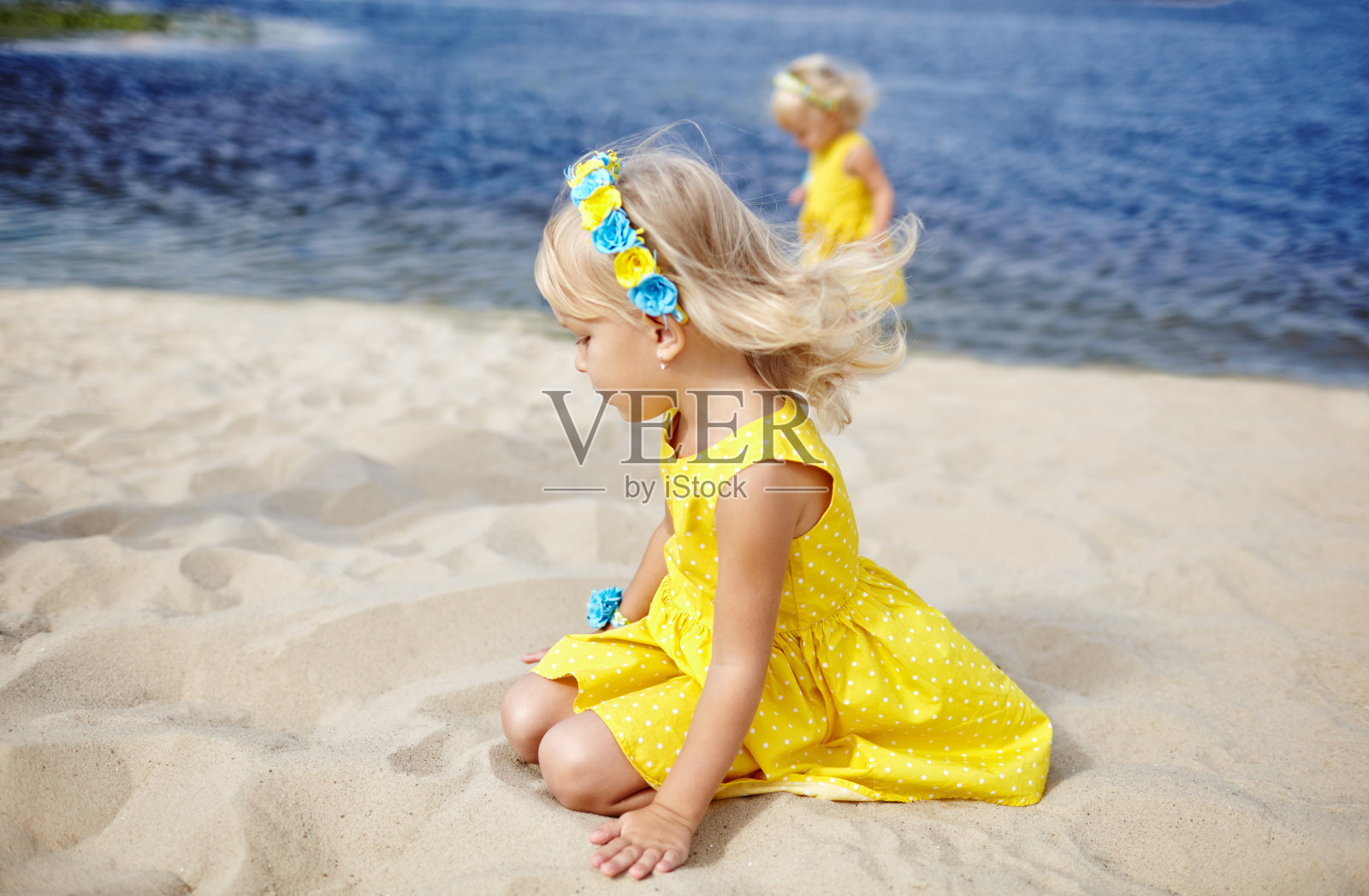 可爱的孩子穿着衣服在户外摆姿势。小女孩们在海边休息。女孩们在一起玩。夏季、童年和休闲的概念照片摄影图片