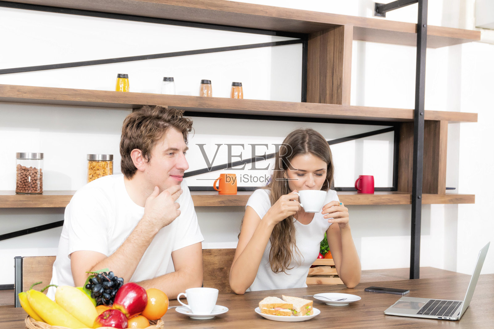 幸福的夫妇在家里一起吃早餐。照片摄影图片