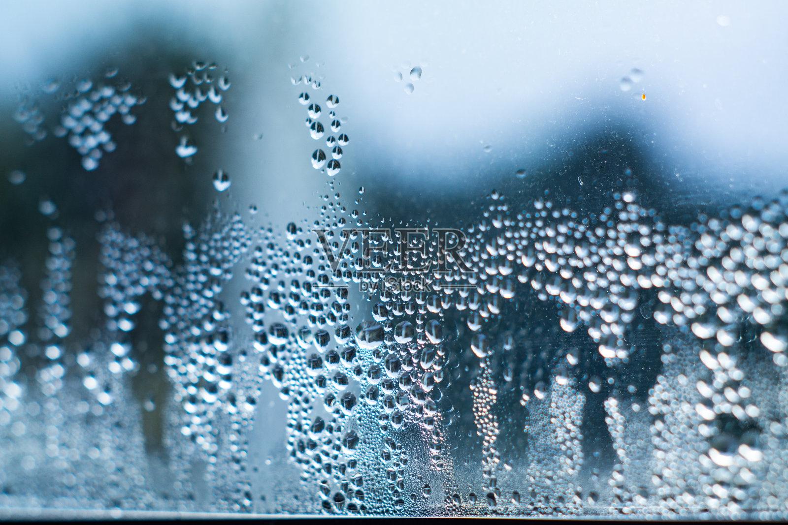 水滴在玻璃上近距离拍摄出焦点蓝色散景背景照片摄影图片