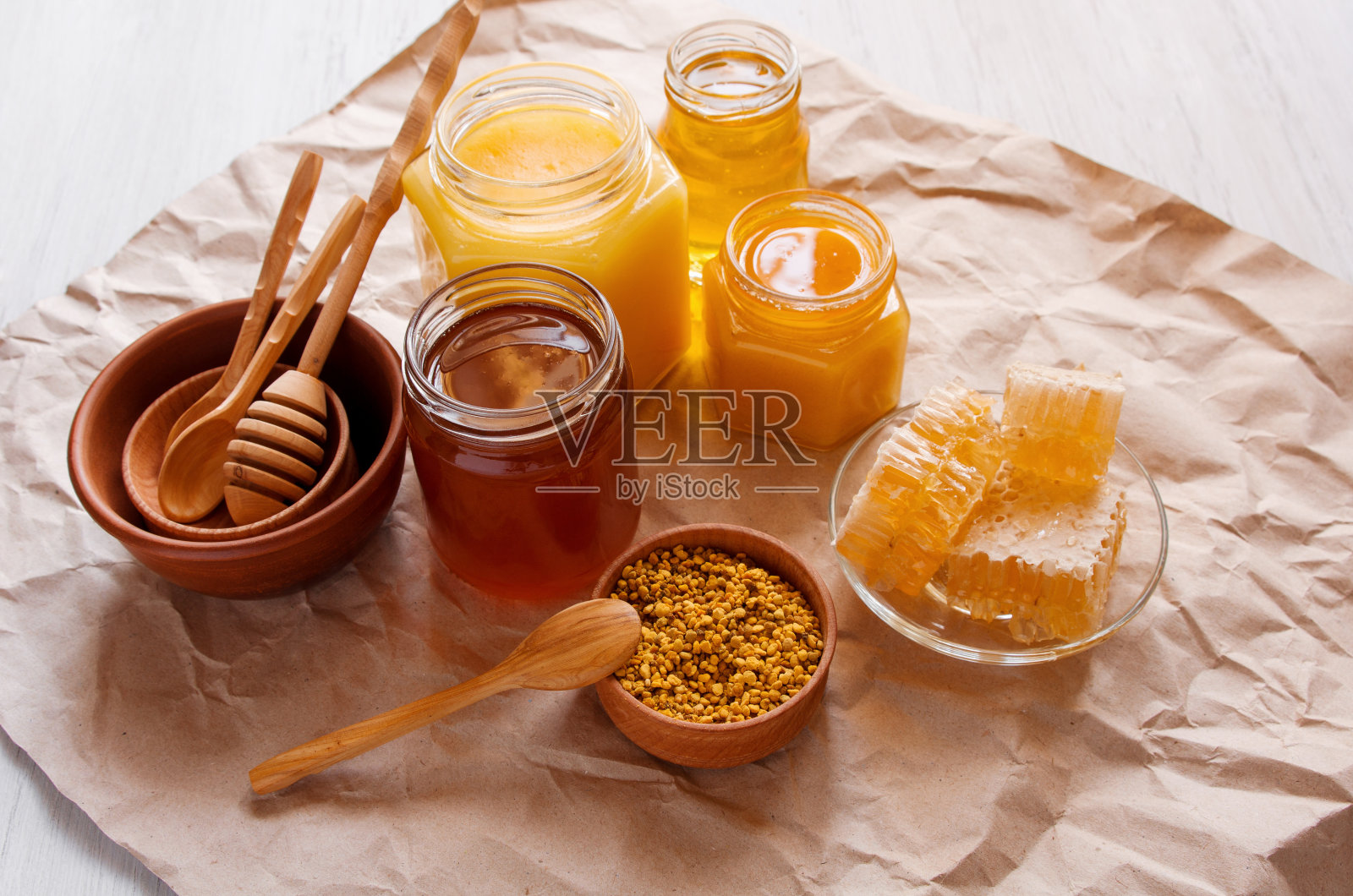 玻璃瓶里的蜂液花蜜，桌上的花粉和蜂房照片摄影图片