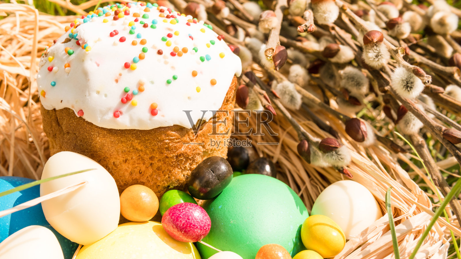 在春天的草地上，甜蜜的复活节蛋糕和五颜六色的彩蛋的特写照片摄影图片