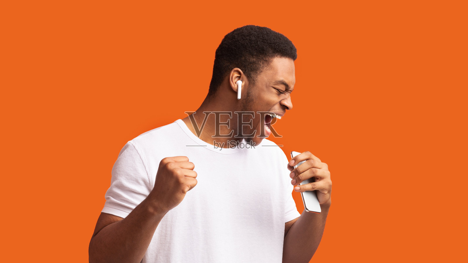 一名黑人戴着无线耳机唱歌照片摄影图片