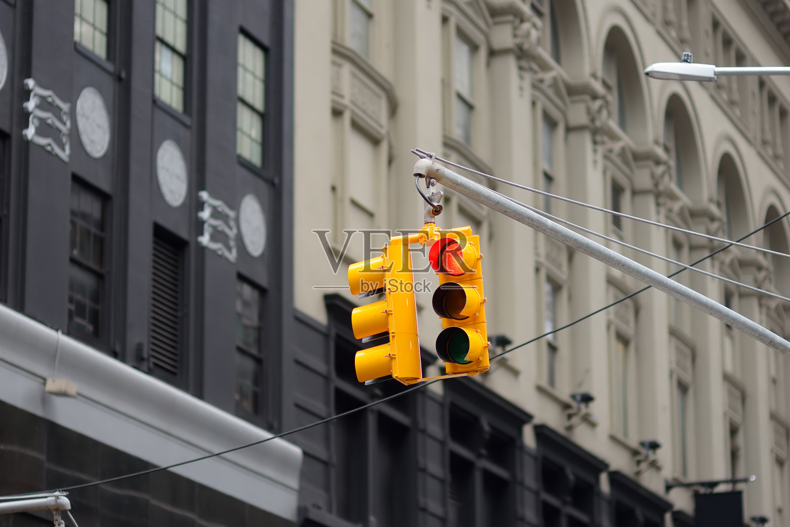 摩天大楼背景上的纽约黄色交通灯。红色的停止信号。照片摄影图片