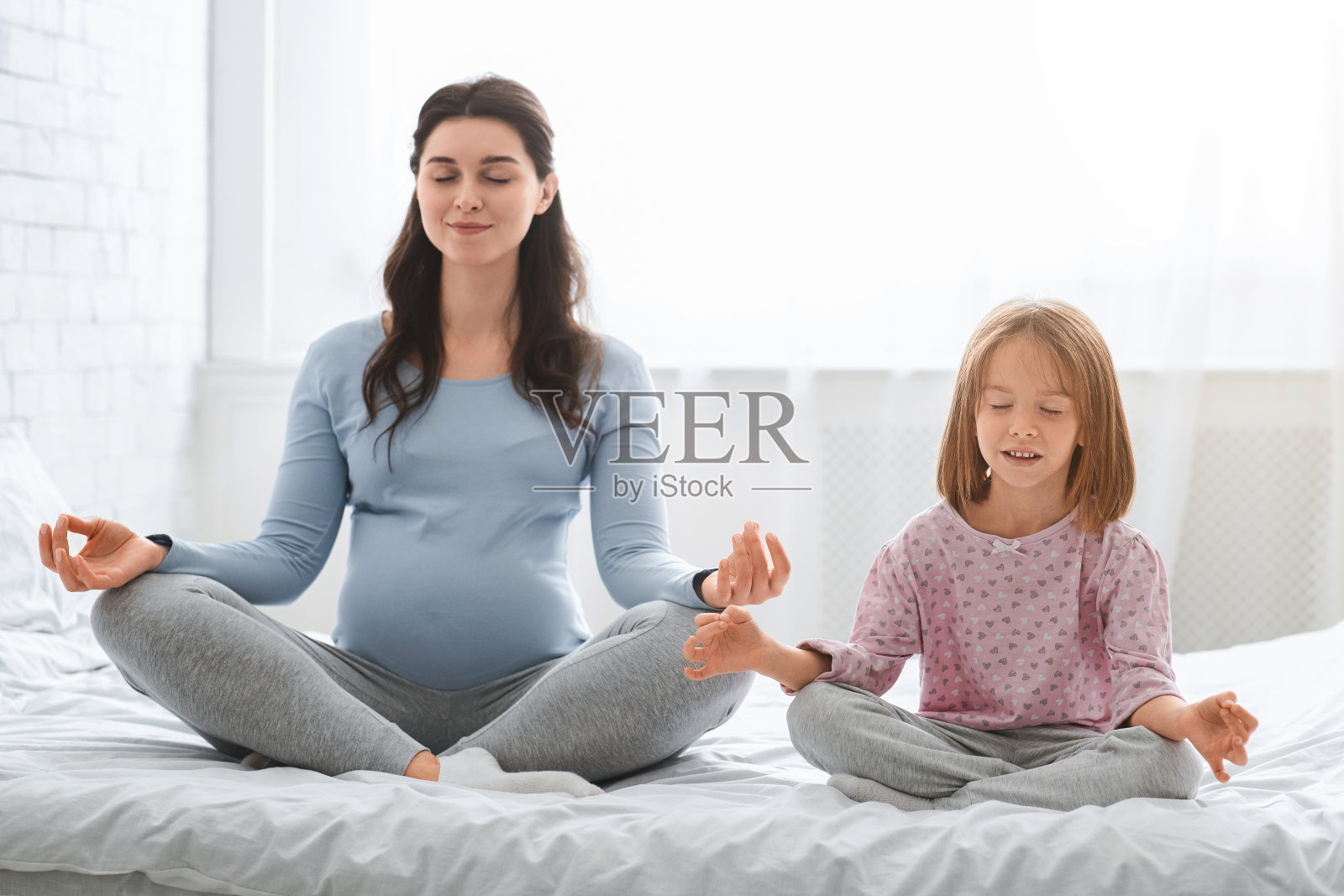 怀孕的妈妈和小女儿一起做瑜伽照片摄影图片