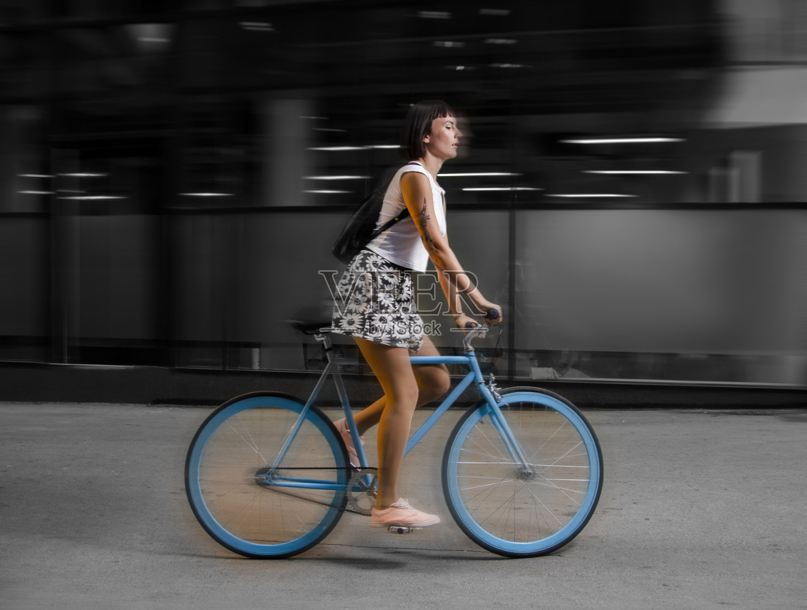 年轻时髦的女孩开着蓝色自行车在城市里照片摄影图片