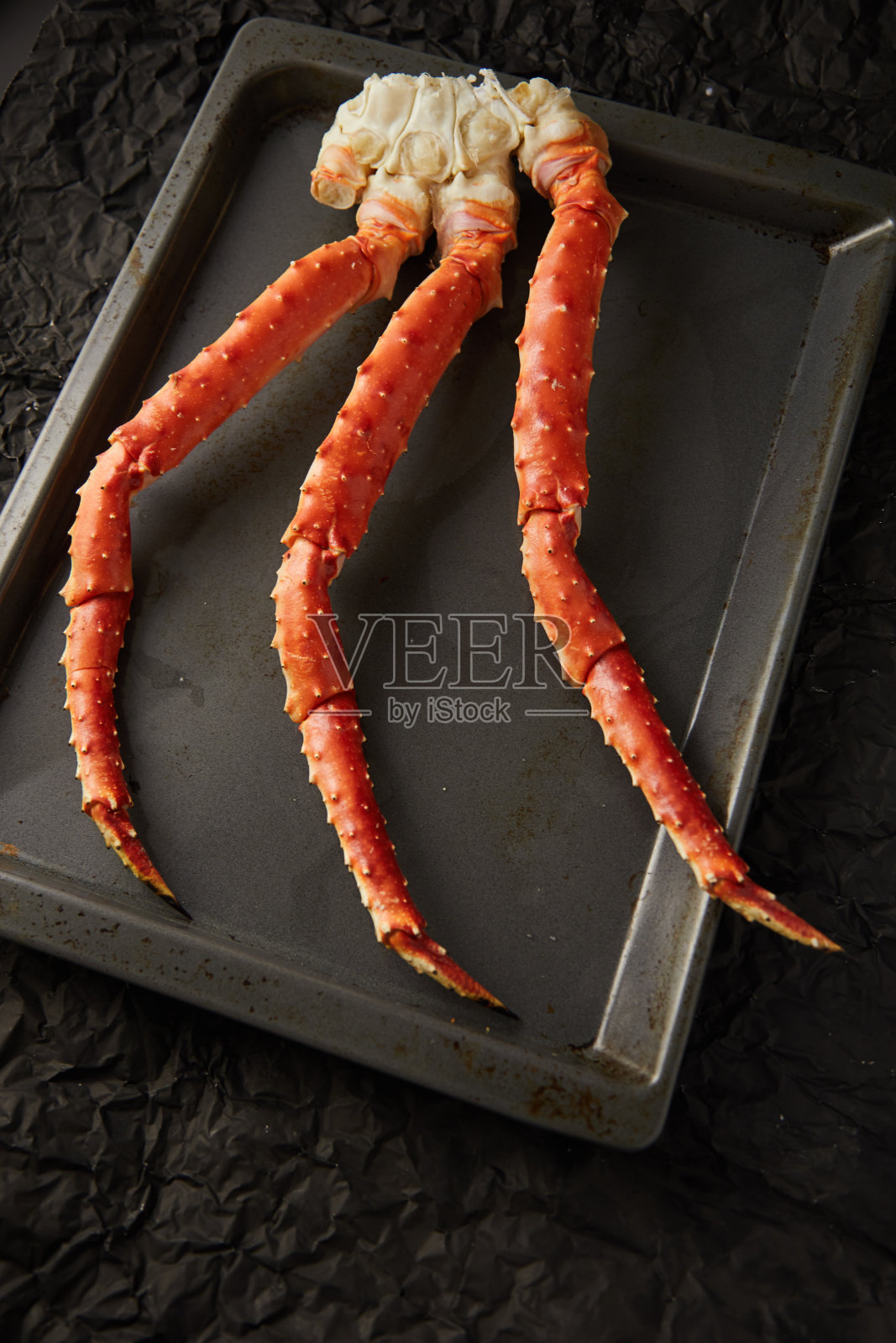 烤盘上的新鲜螃蟹趾骨的图片，背景是带有拷贝空间的黑色照片摄影图片