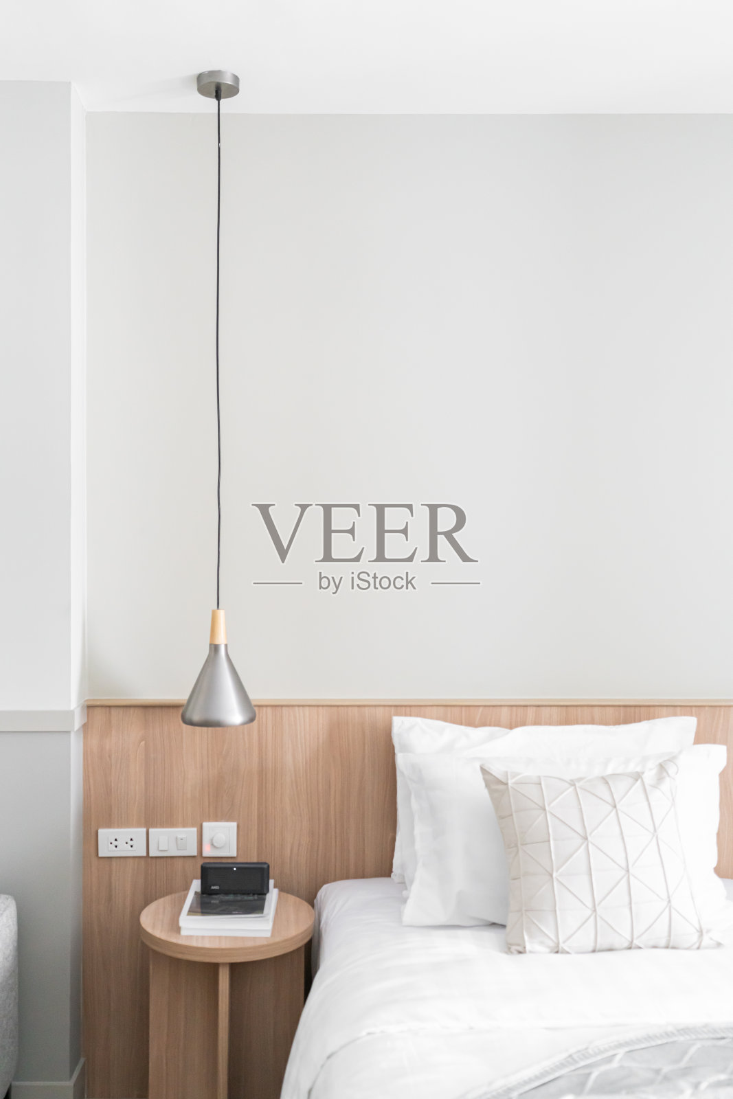 卧室角落配有不锈钢吊灯和木质边桌，现代斯堪的纳维亚风格/现代简约/舒适的室内设计理念照片摄影图片
