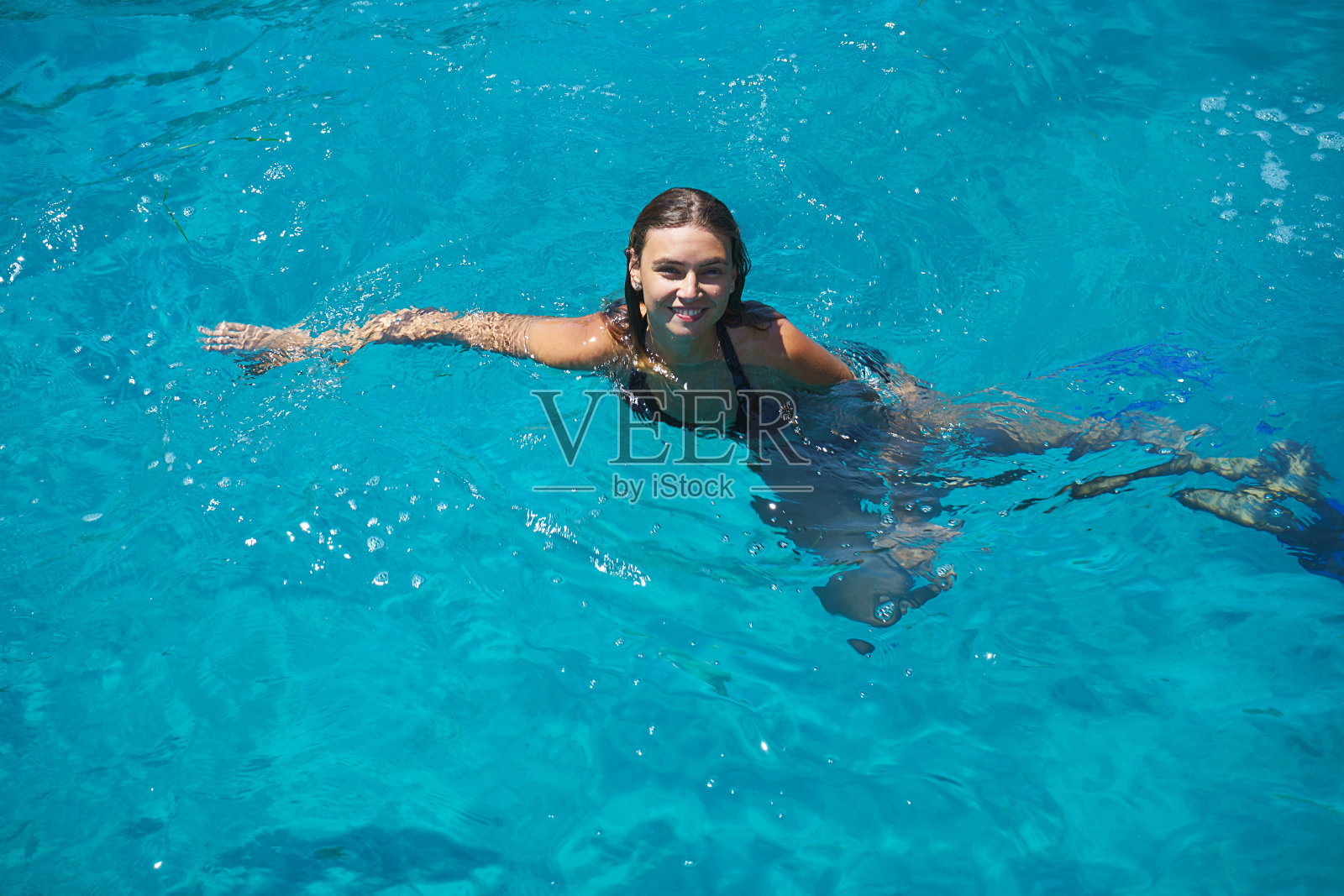 年轻快乐美丽的女人感到乐趣在绿松石海在暑假游泳。照片摄影图片