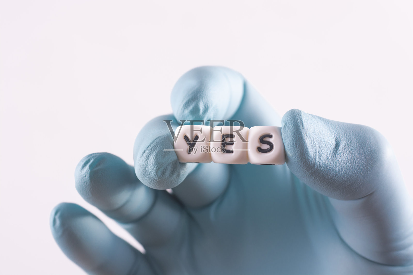 “YES”这个词是由手里的白色塑料立方体组成的。选择正确的决定。照片摄影图片