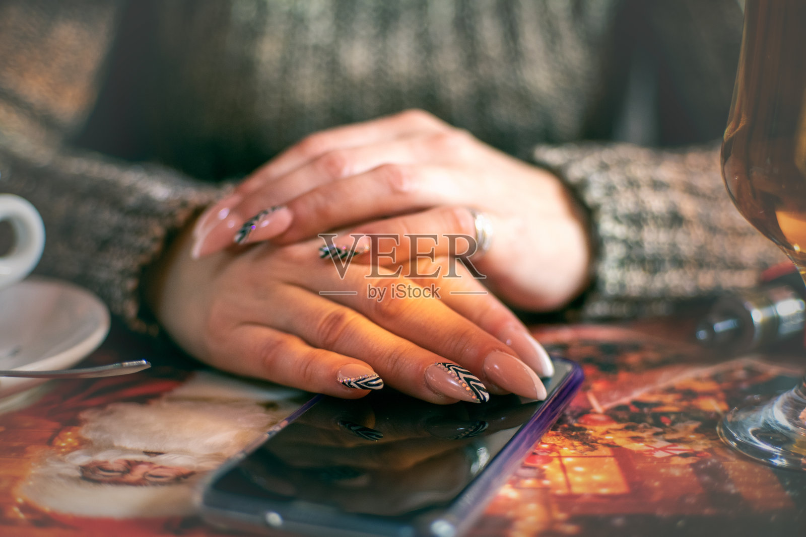 一个修过指甲的女人手拿着智能手机在咖啡馆里照片摄影图片