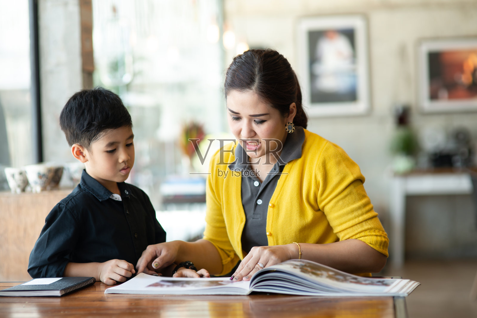 亚洲母亲教儿子读书，生活理念。照片摄影图片