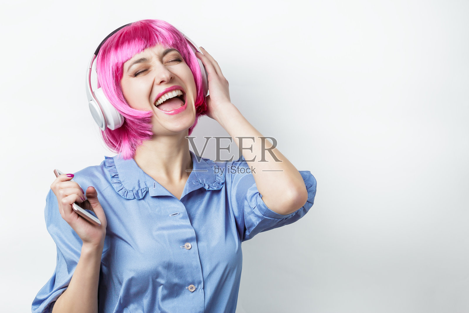快乐的女孩戴着粉色假发和耳机照片摄影图片