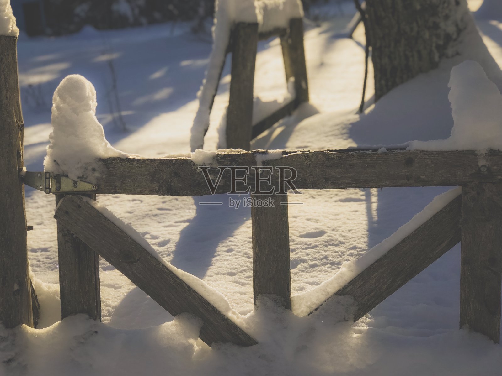 在中西部的一个农场，旧的篱笆门被雪覆盖。照片摄影图片
