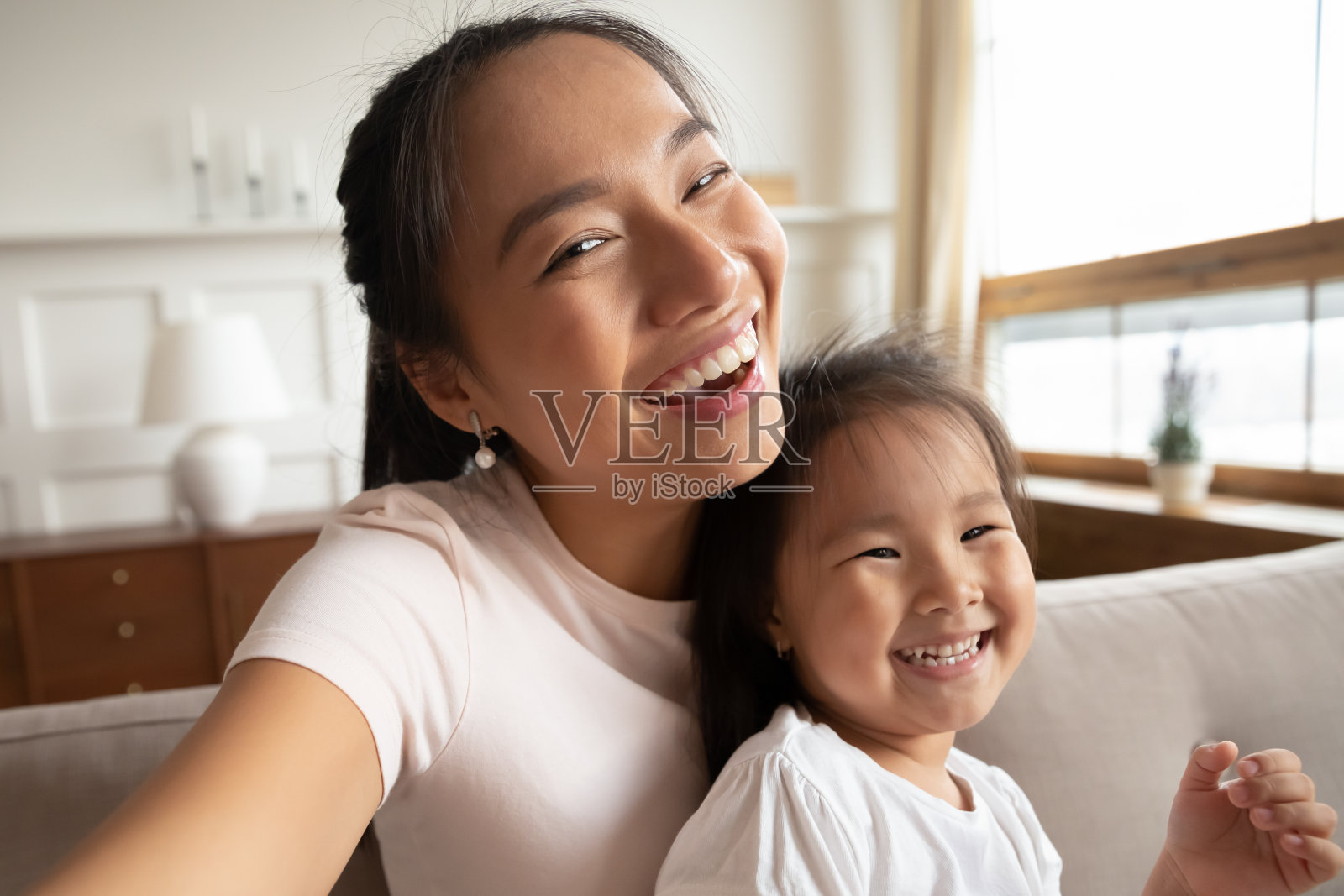微笑的亚洲妈妈和小女儿的自画像照片摄影图片