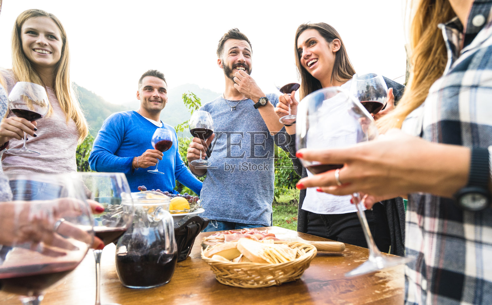 朋友群在餐厅花园玩-年轻人一起享受收获的时间在农场葡萄园-友谊概念与千禧一代在户外葡萄酒日落照片摄影图片