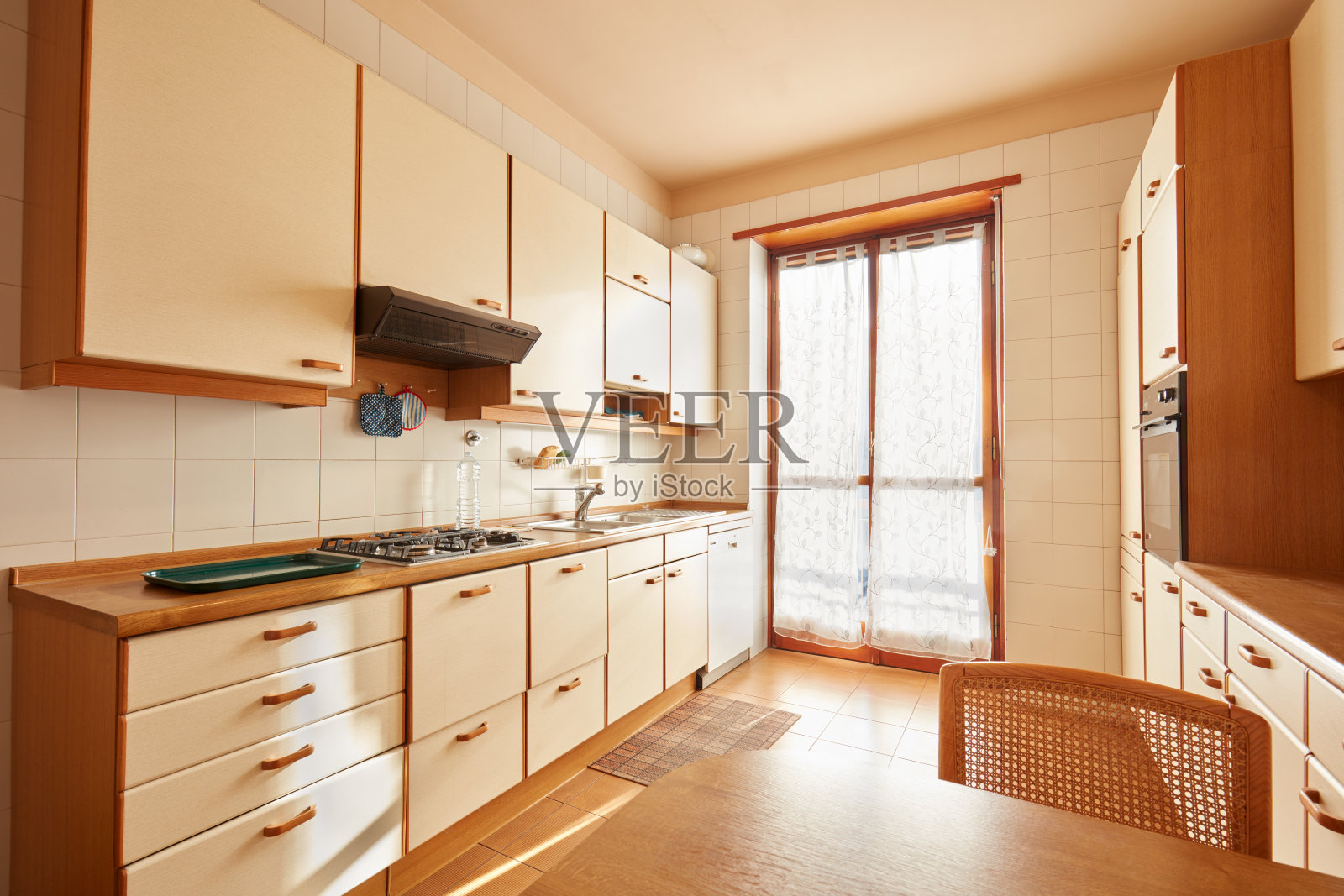 厨房内部与木桌在阳光明媚的日子在正常的公寓照片摄影图片