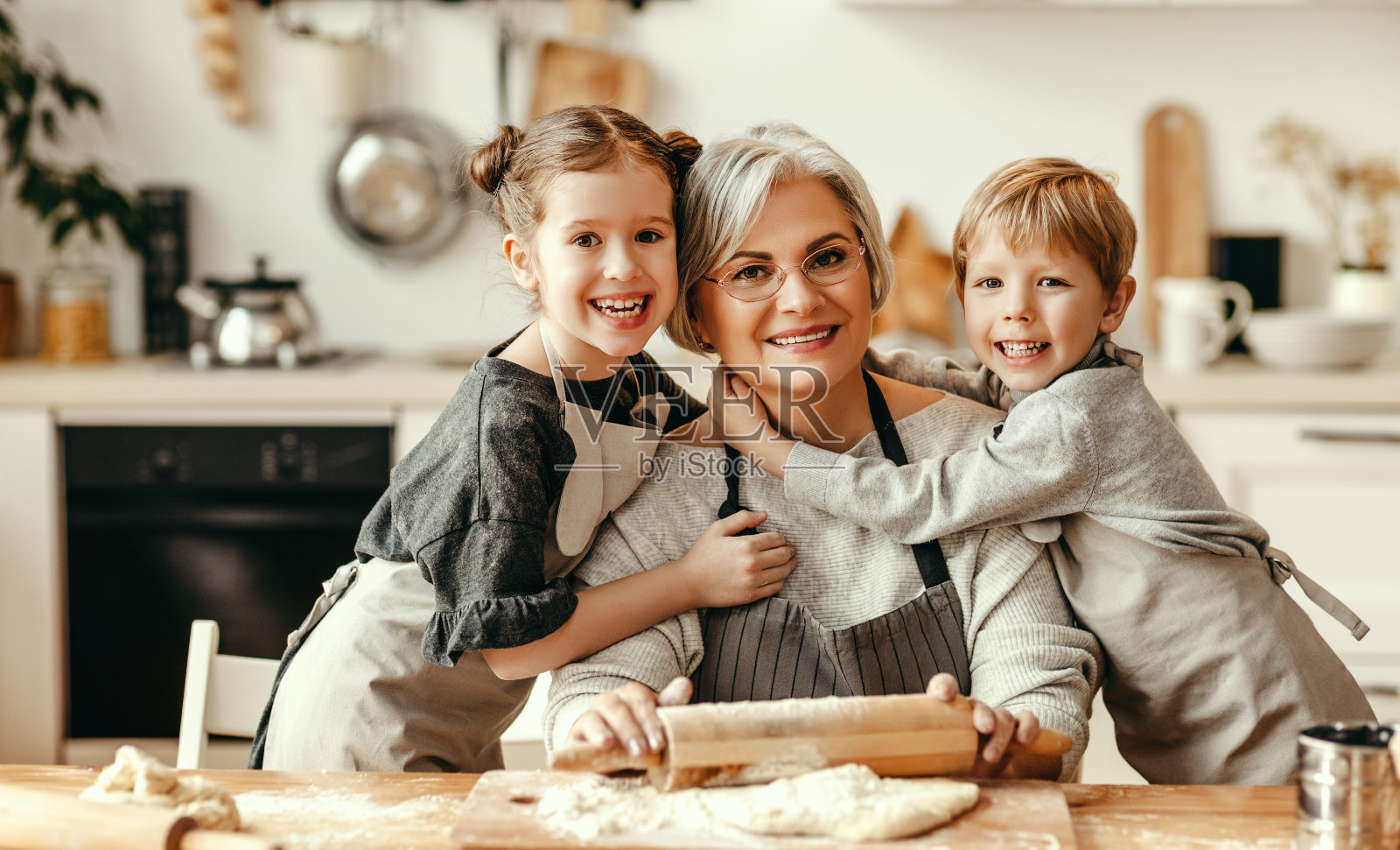 快乐的一家人，奶奶和孙子在厨房做饭，揉面团，烤饼干照片摄影图片