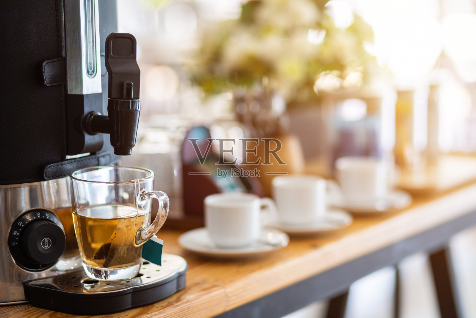 特写的茶从咖啡机和咖啡杯上装饰在酒店餐桌上照片摄影图片
