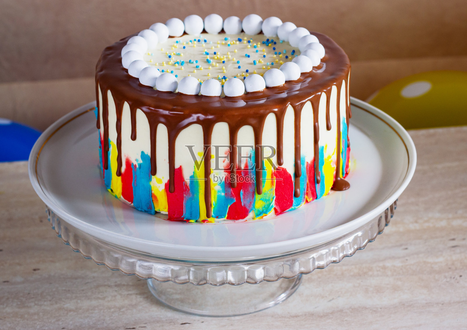 明亮的生日蛋糕与巧克力在一个轻的背景与气球照片摄影图片