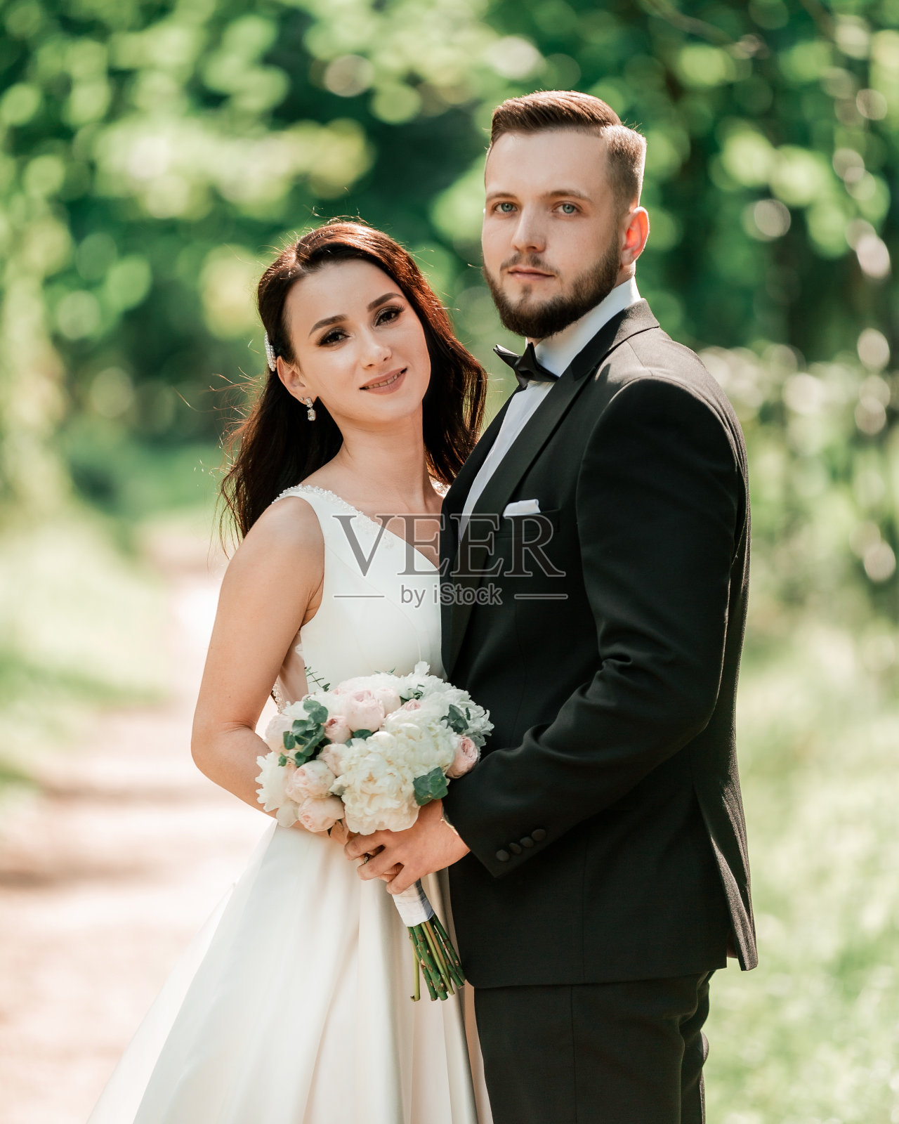 幸福的新娘和新郎站在婚礼拱门下照片摄影图片
