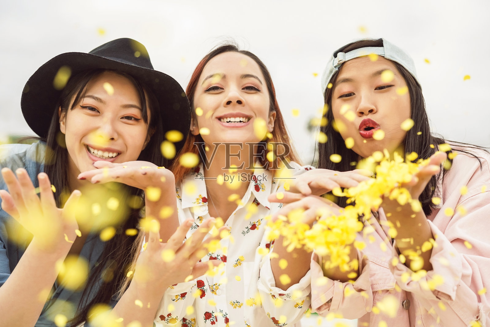 快乐的亚洲朋友在户外扔五彩纸屑-年轻时尚的人庆祝狂欢节甚至-派对娱乐和青年假日的生活理念照片摄影图片
